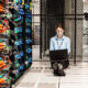 Caucasian woman technician working on computer servers in a server farm.