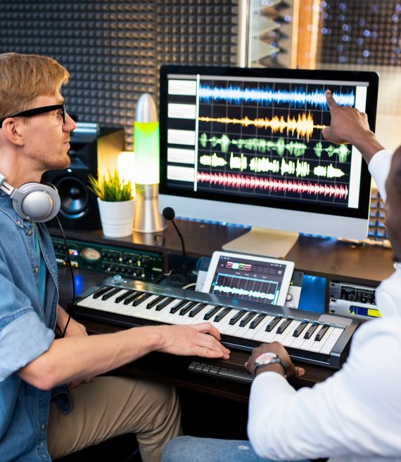 One of contemporary musicians pointing at sound waveform on computer screen